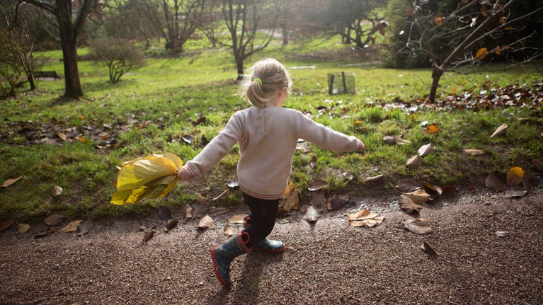 Girl in the garden at Killerton holding a large leaf